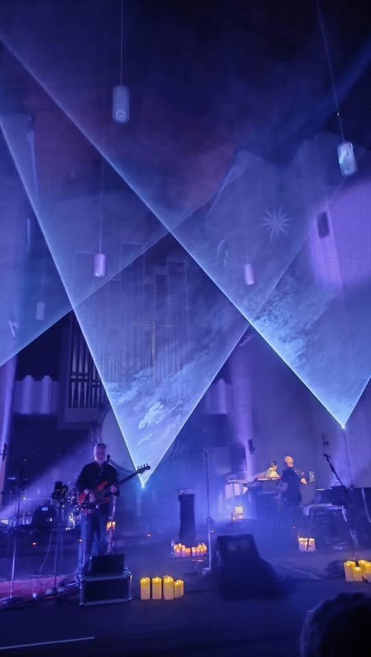 Blaue Laserfächer über einer Live-Band